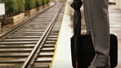 A person standing by train tracks.