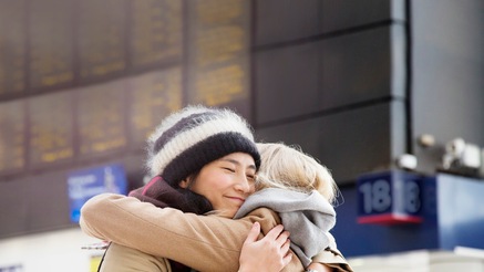 Photograph of two people hugging on a street