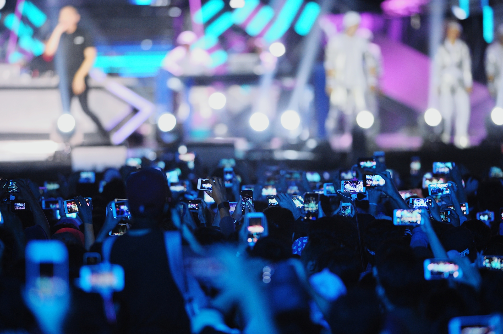 Crowd of people holding up their smart phones to take pictures