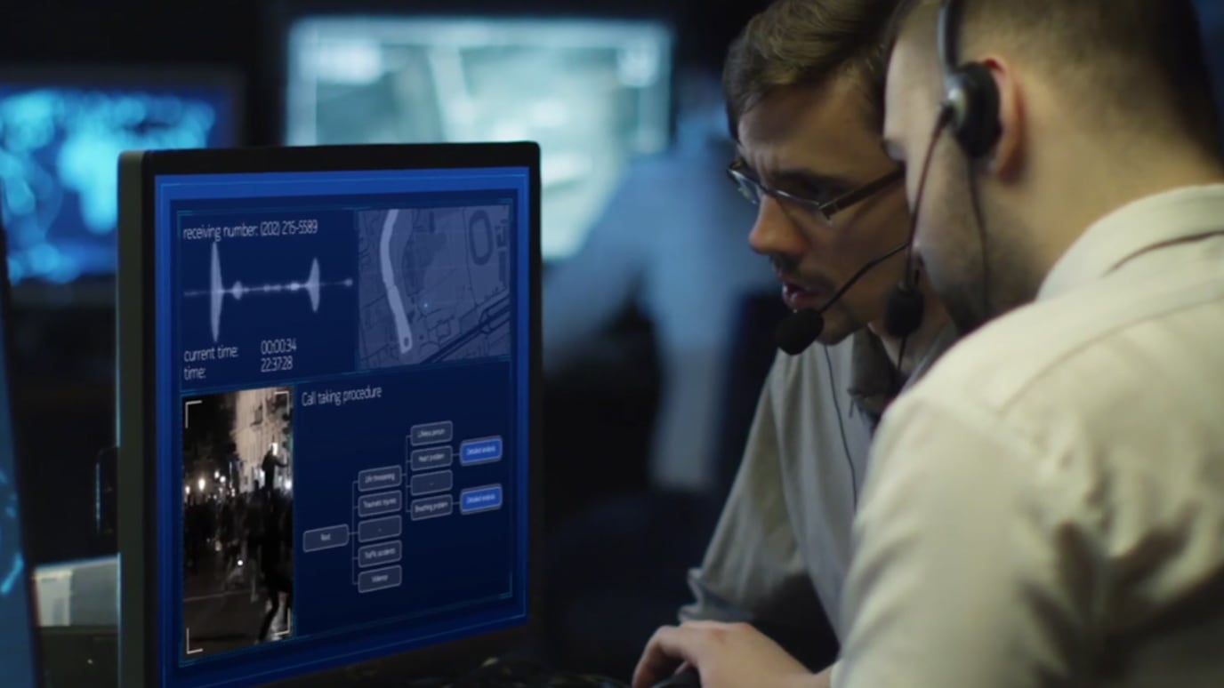 Men with headsets in situation room look at monitor screen