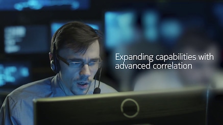 Man wearing headset in situation room looking at monitor screen