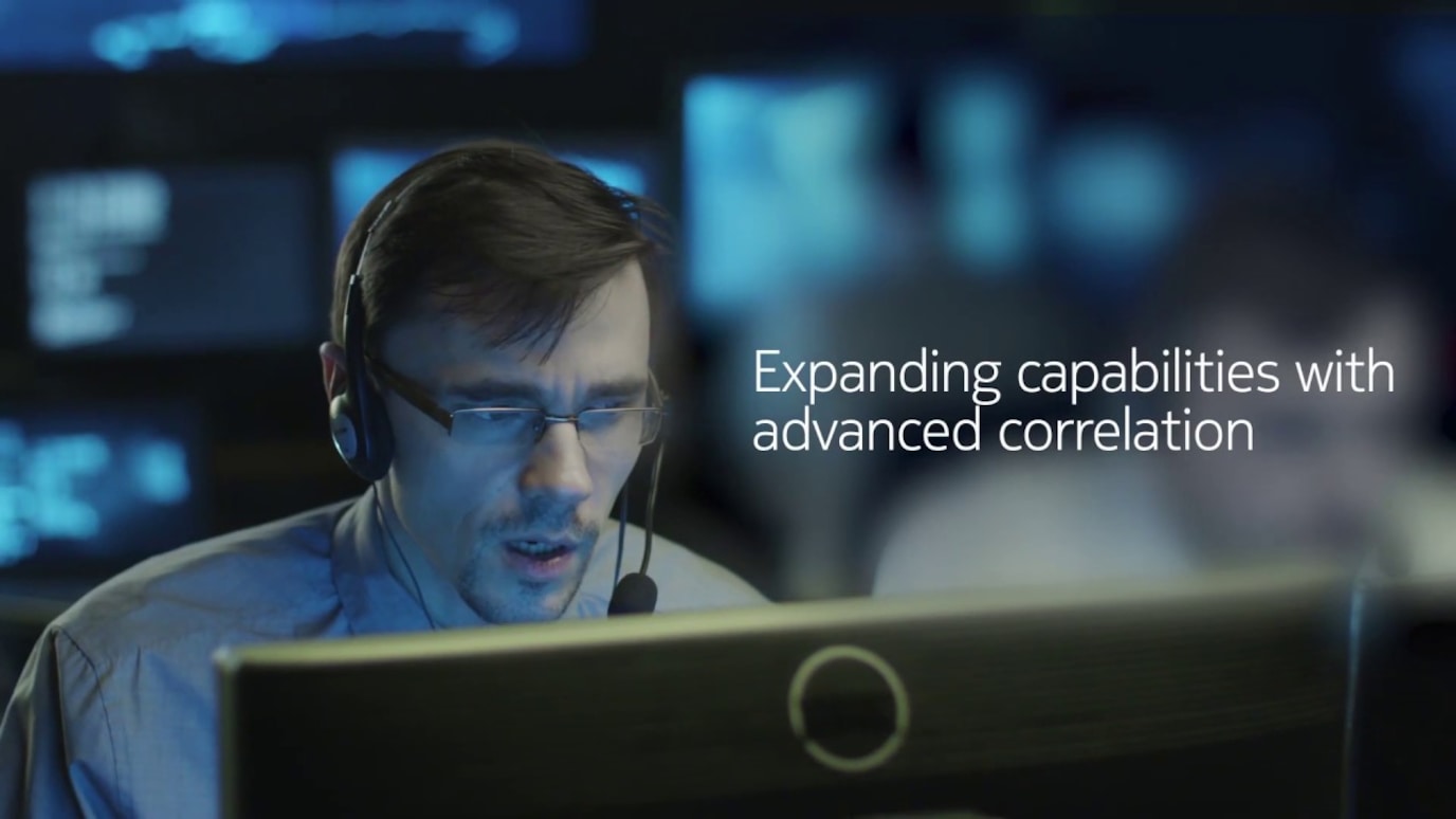 Man wearing headset in situation room looking at monitor screen