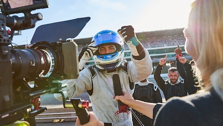 A racecar driver being interviewed on camera