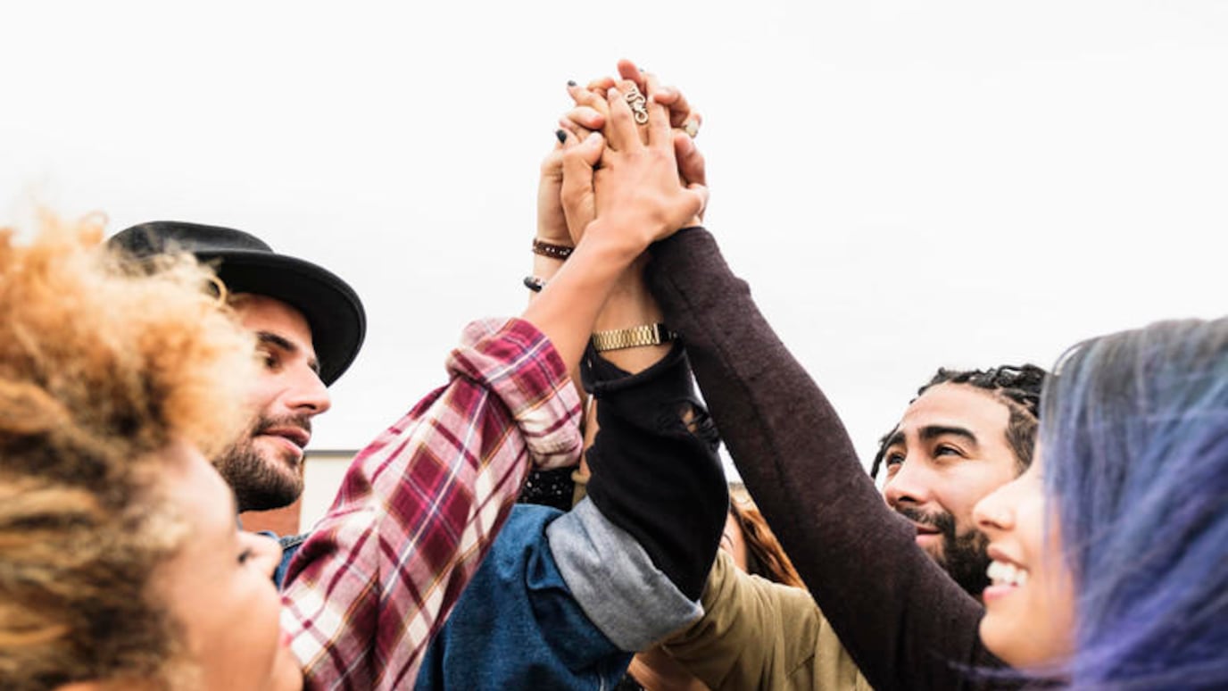 people cheering together and holding hands
