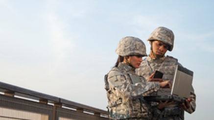 Two soldiers looking at laptop