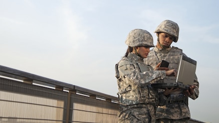 Two soldiers looking at tablet device