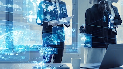 An image of people looking at different graphs on multiple screens.