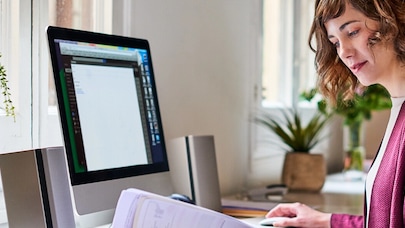 A picture of a person working in a bright home office setting.