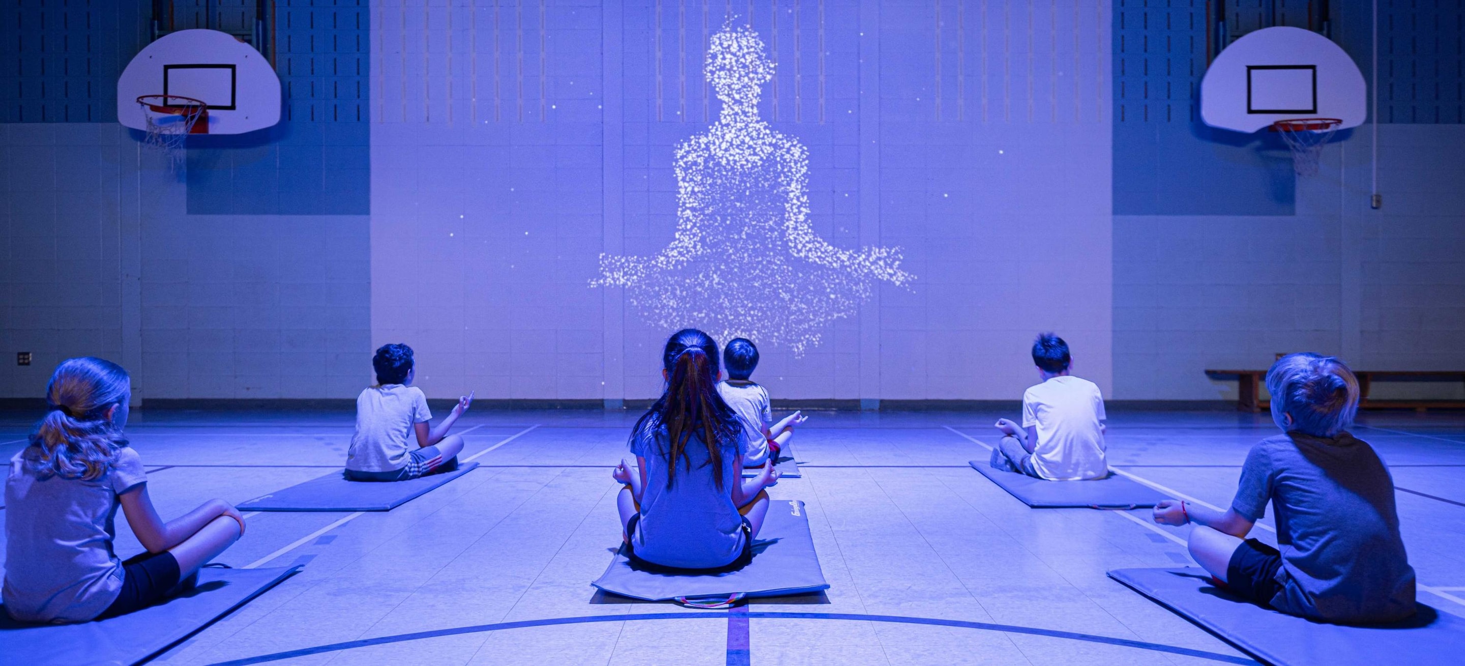 Kids doing yoga in a gymnasium