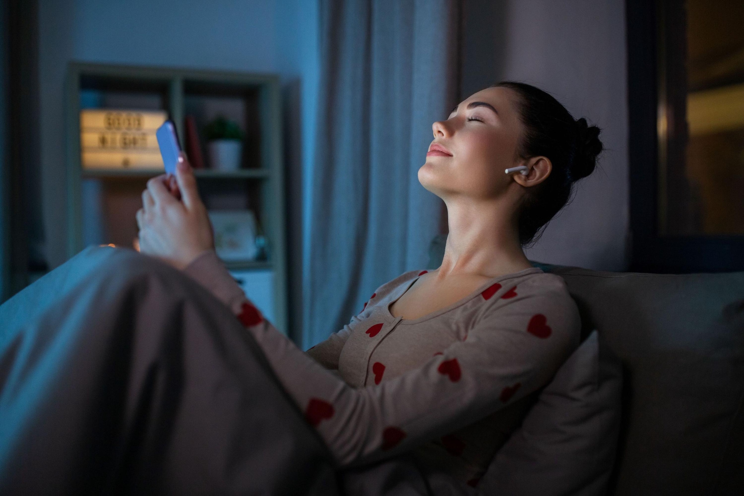 Woman holding a smartphone in her hands and listening to music