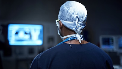 Doctor looking at monitor in darkened room