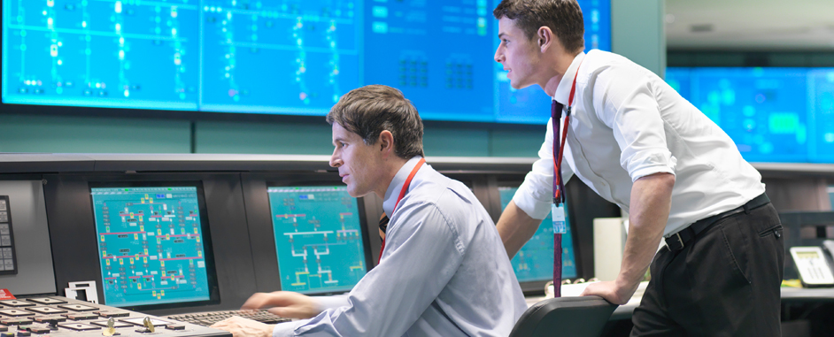 Side view of two people in a control room