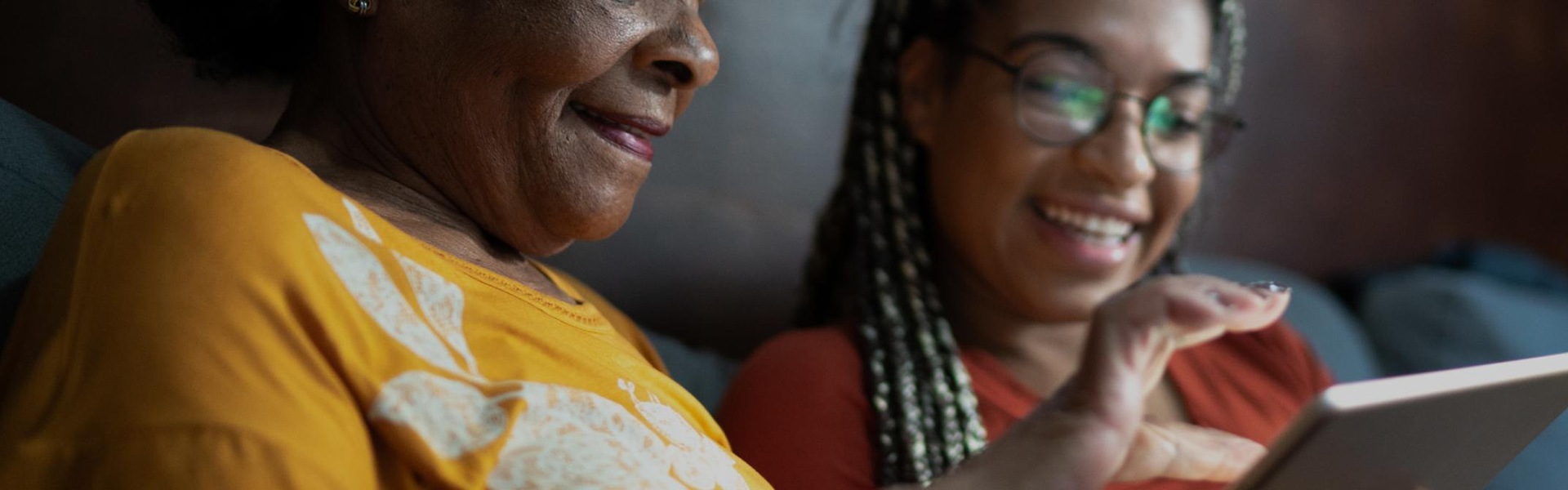 Two women on a sofa looking at a tablet screen