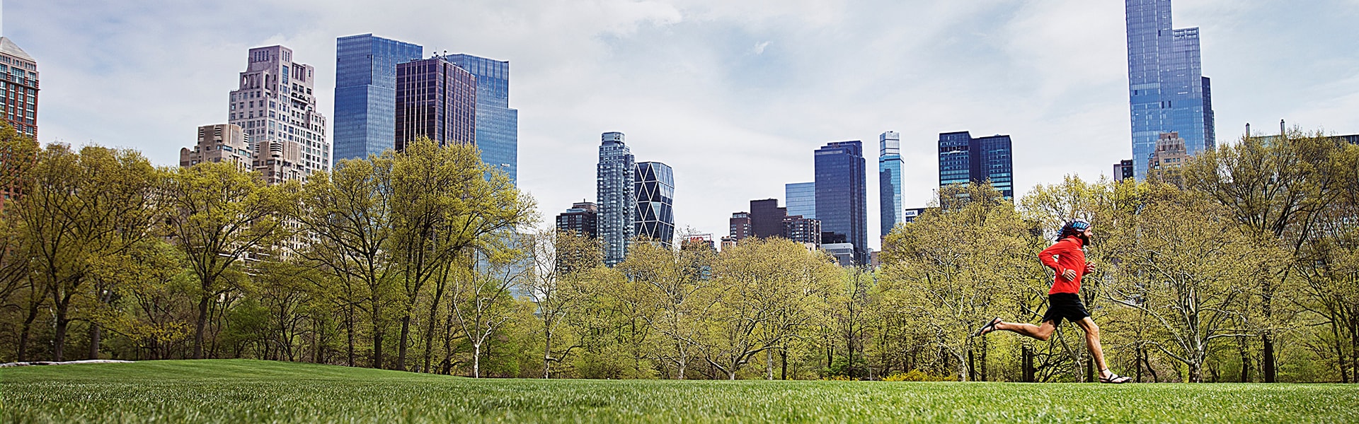 Runner in Central Park with skyscrapers in background
