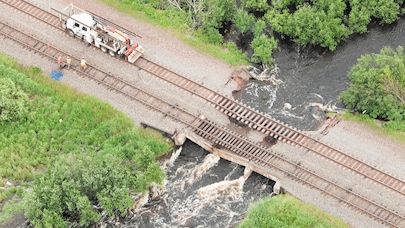 Repair vehicle on rail tracks on damaged bridge over river