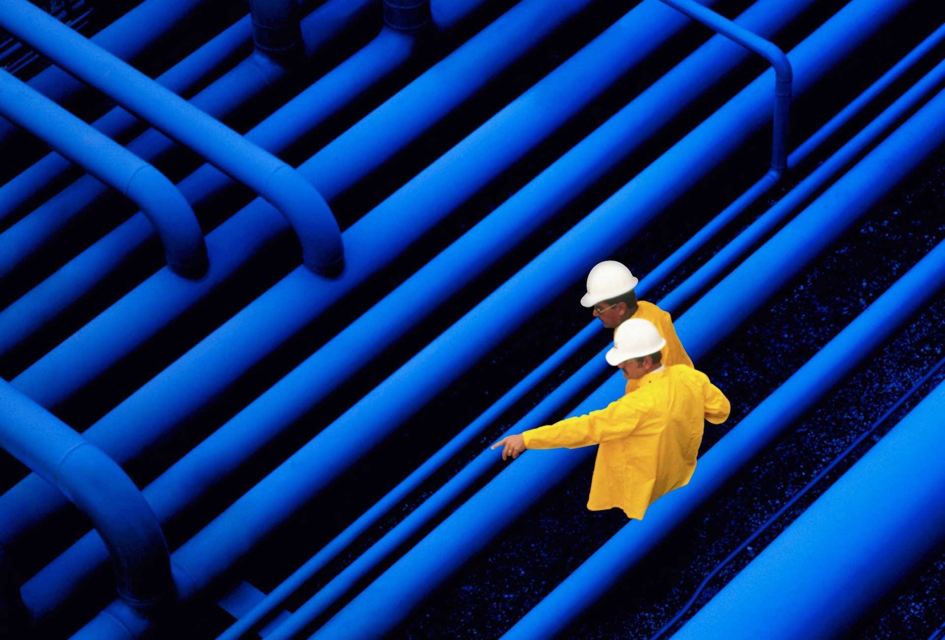 two workers inspecting pipes