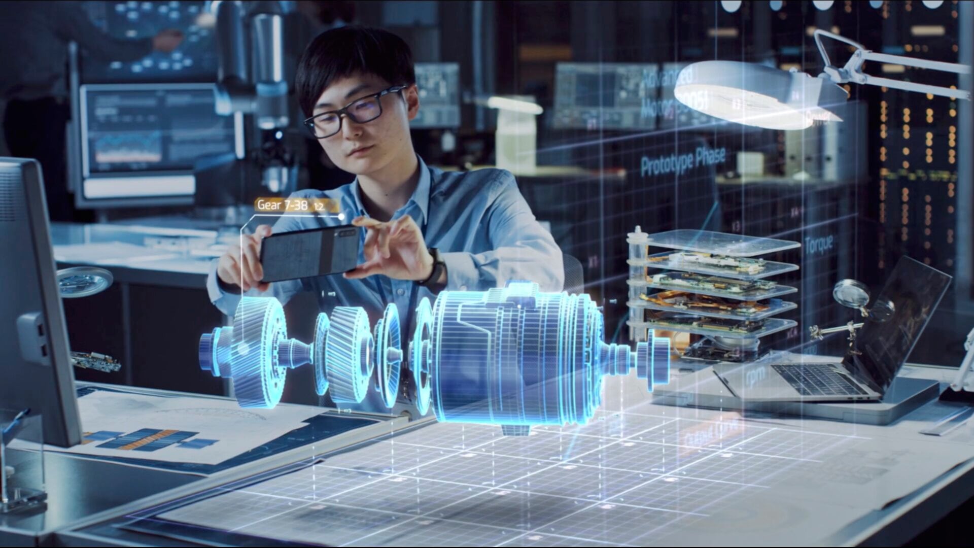 A person using a smartphone to view a 3D model of a gear system, overlaid on a real-world table.