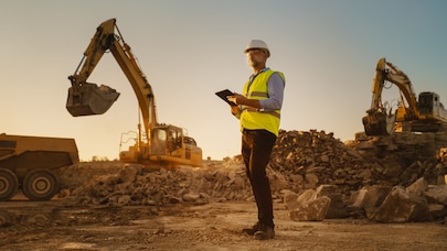 An engineer standing in the middle of a construction site.