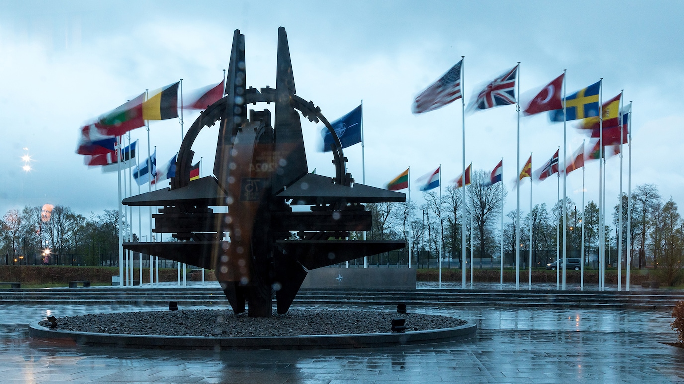 Flags flying in front of sculpture outside NATA headquarters