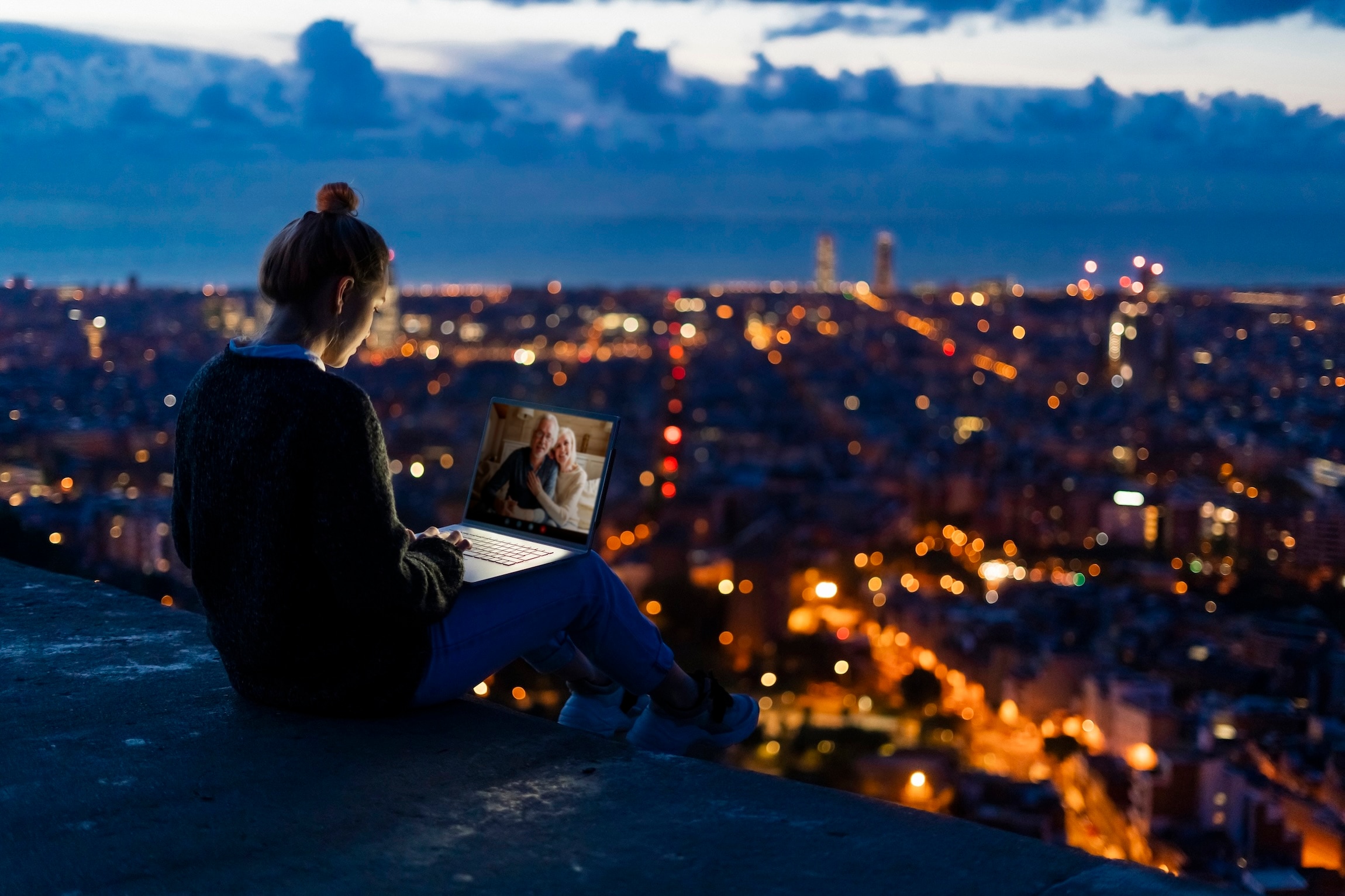 Woman sitting with a laptop in her lap.