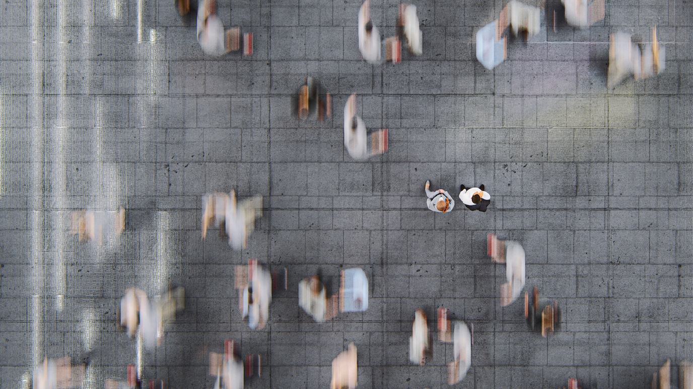 Overhead view of people in crowd. Two people stand out while the other are blurred