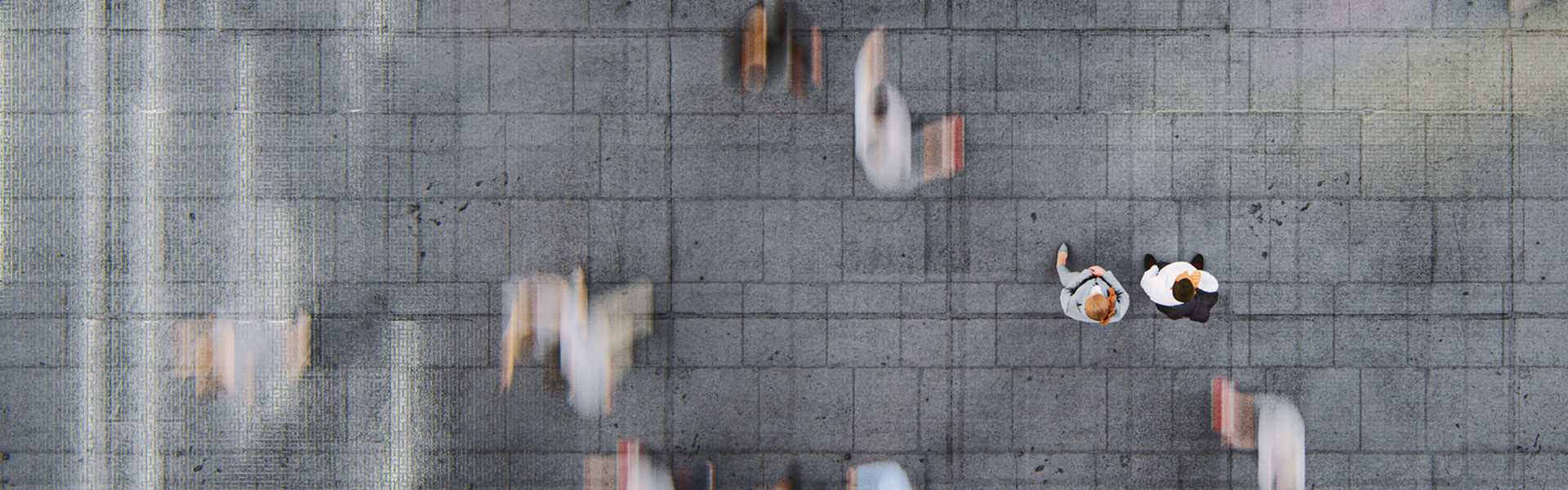 Overhead view of people in crowd. Two people stand out while the other are blurred