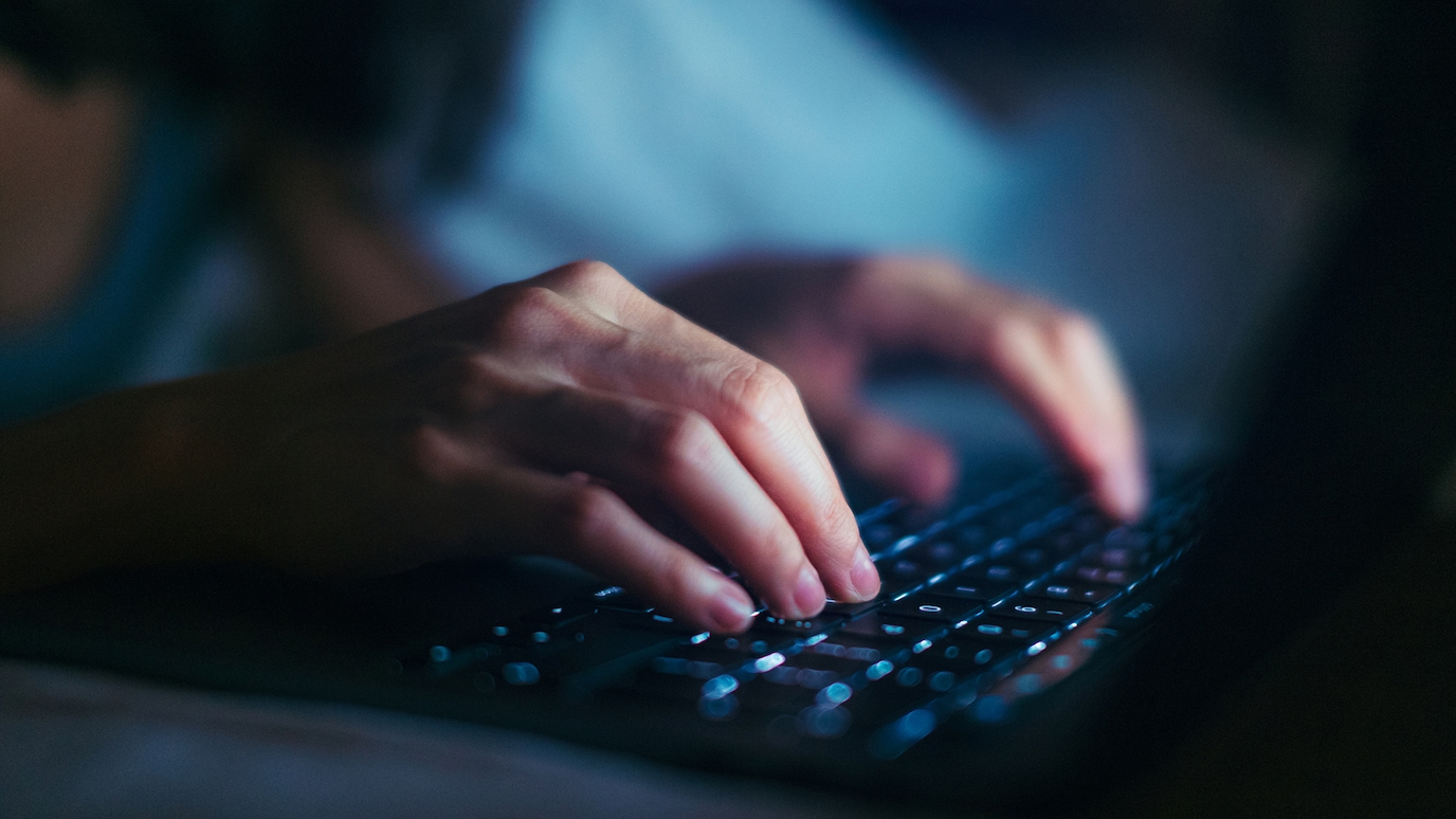 Close-up of hands typing on keyboard