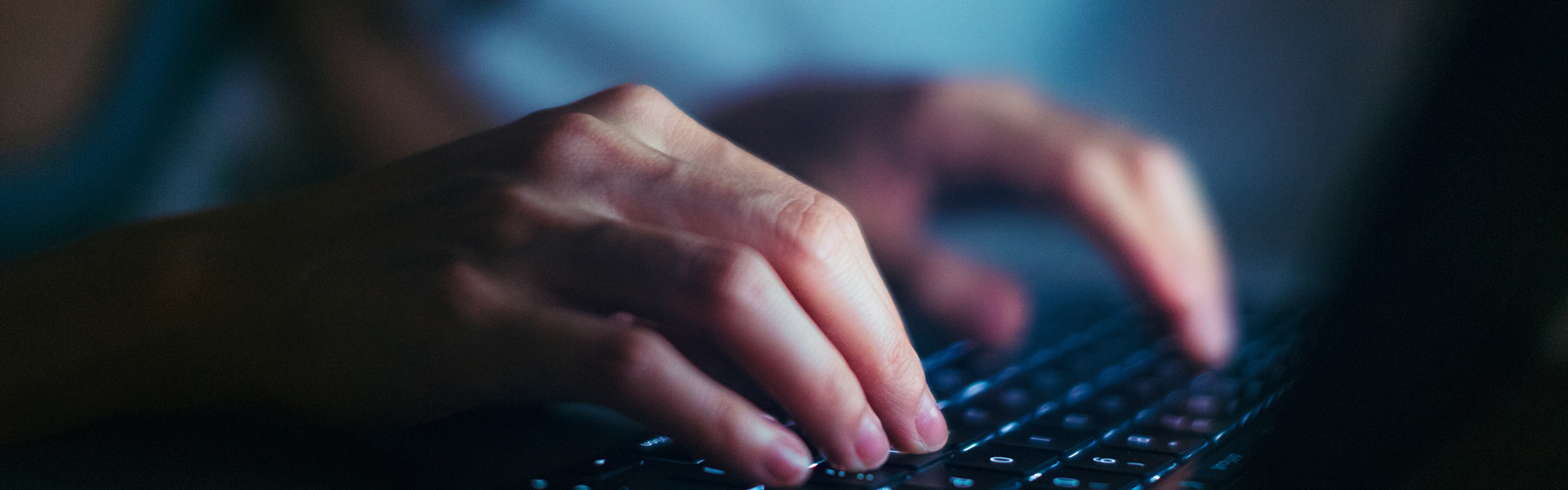 Close-up of hands typing on keyboard
