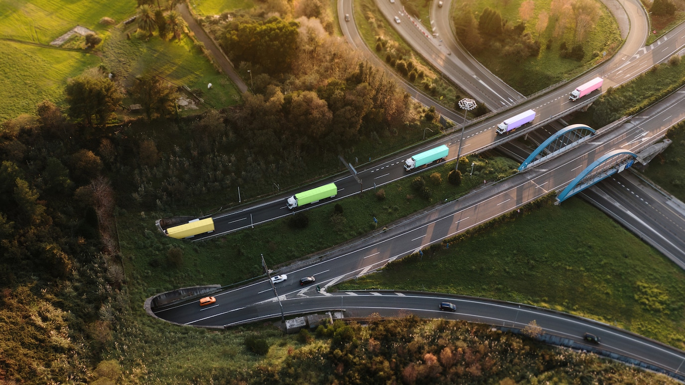 Trucks on road leading into tunnel though hill