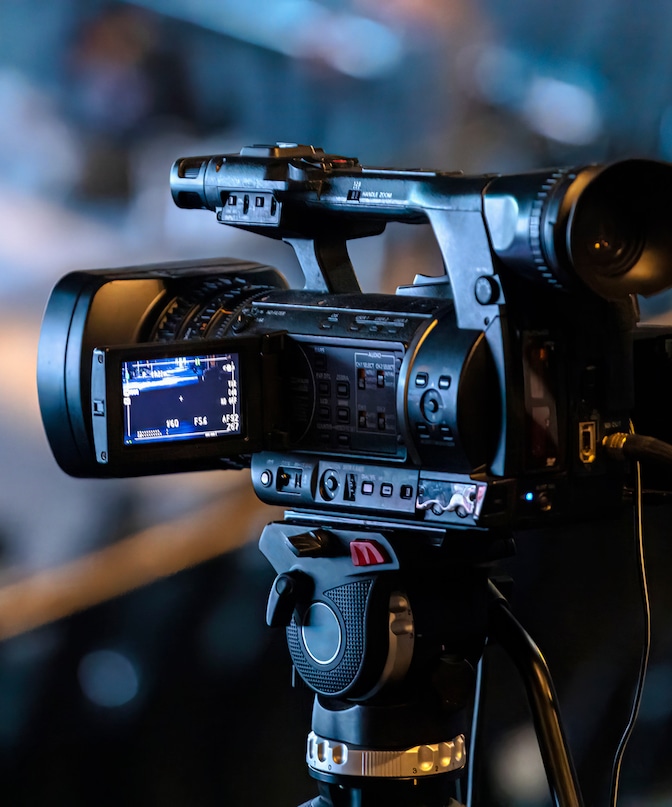 Close up of video camera on tripod from behind