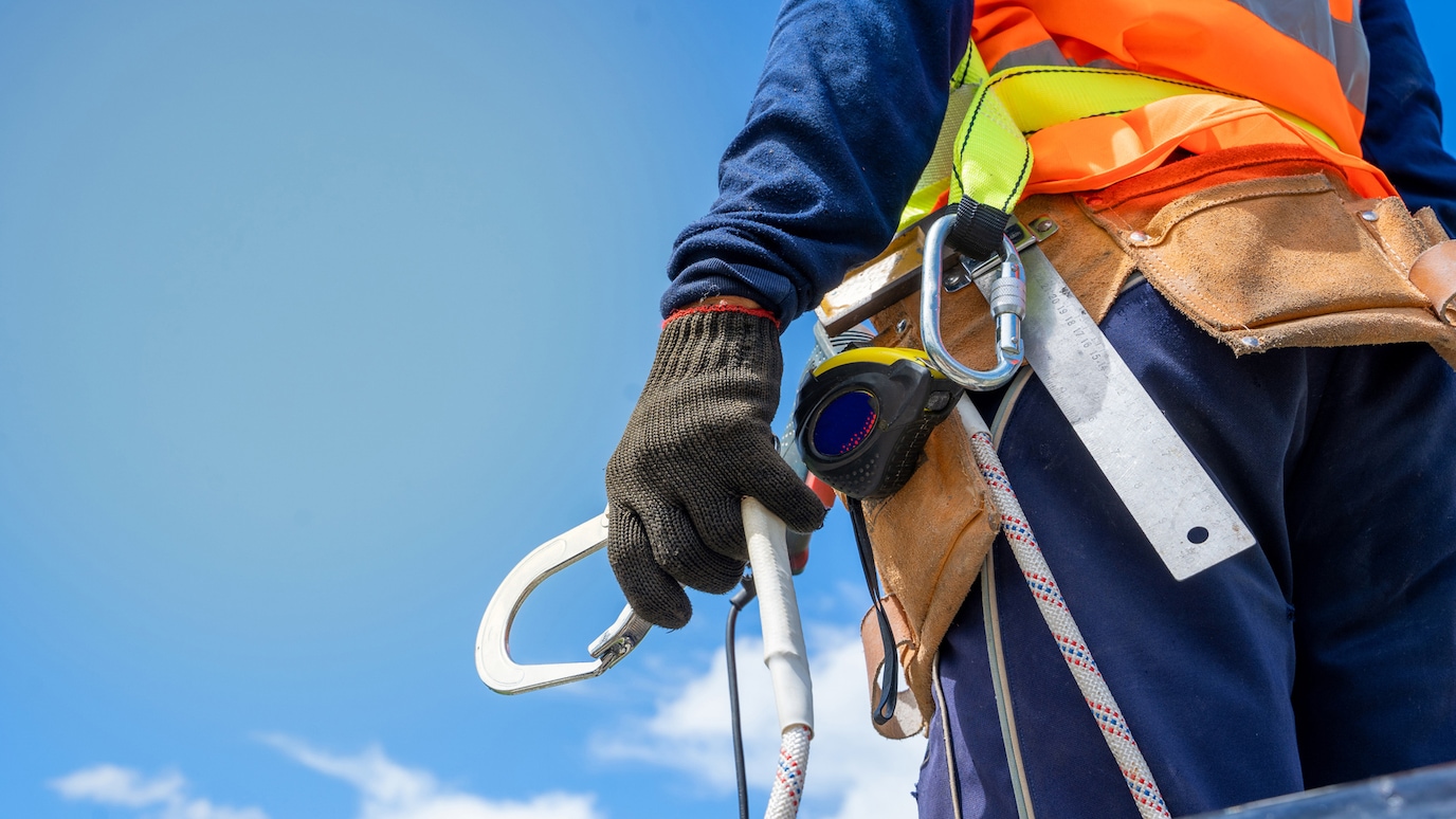 Worker in hi-viz vest holding caribiner