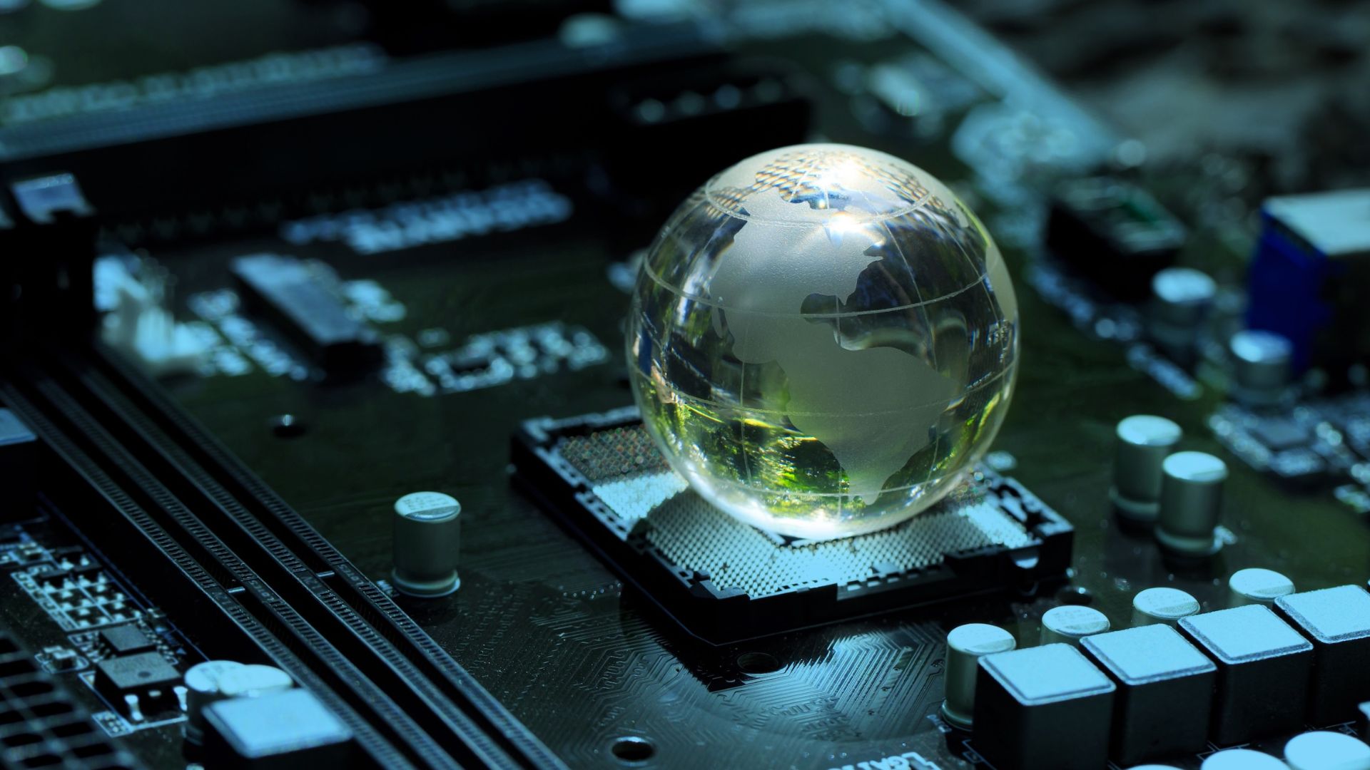 A transparent glass globe, representing Earth, is placed on top of a computer processor socket on a dark green circuit board, symbolizing the intersection of global connectivity and modern technology.