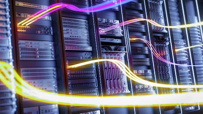 High-speed data flow concept with colorful light trails over modern server racks in a secure data center environment.
