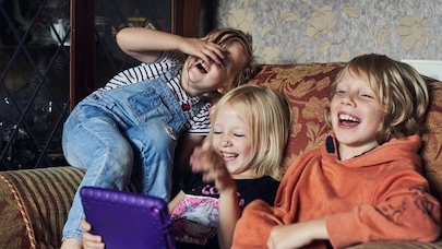 Children on sofa looking at tablet