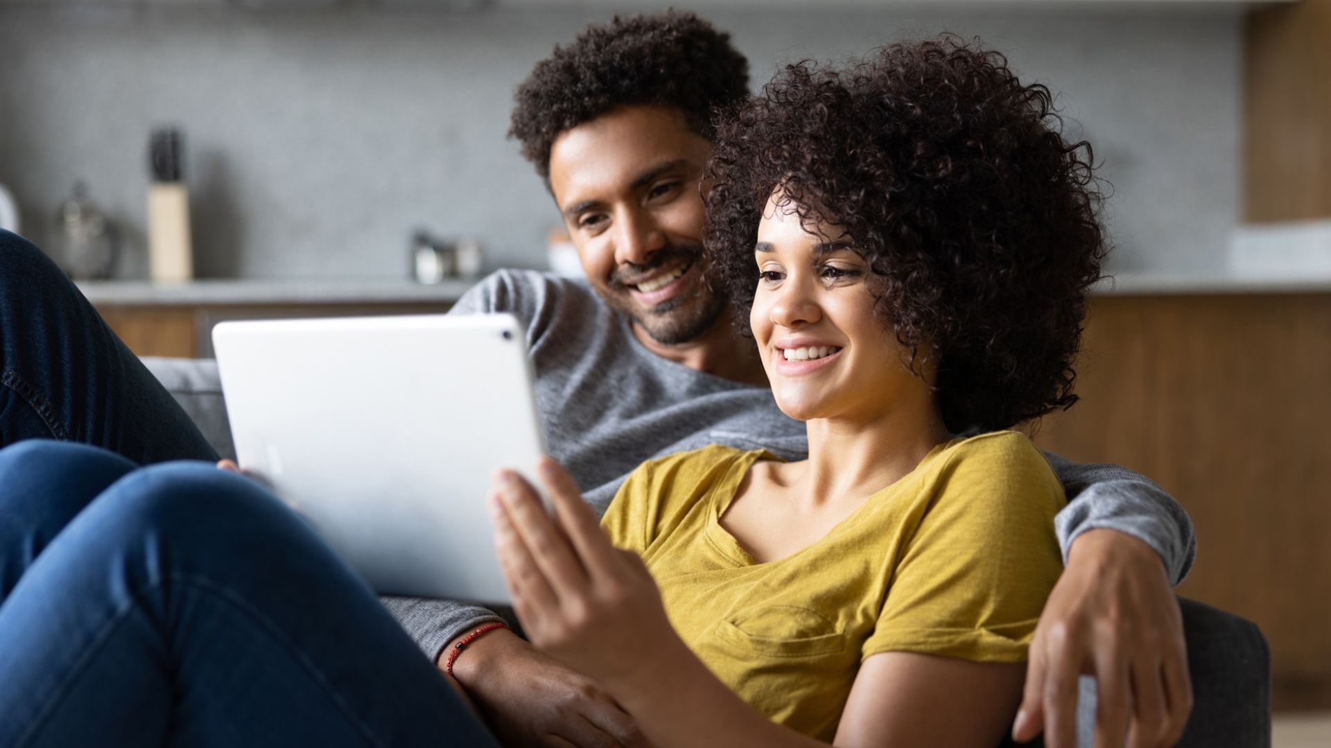 Couple at home streaming video content on a tablet