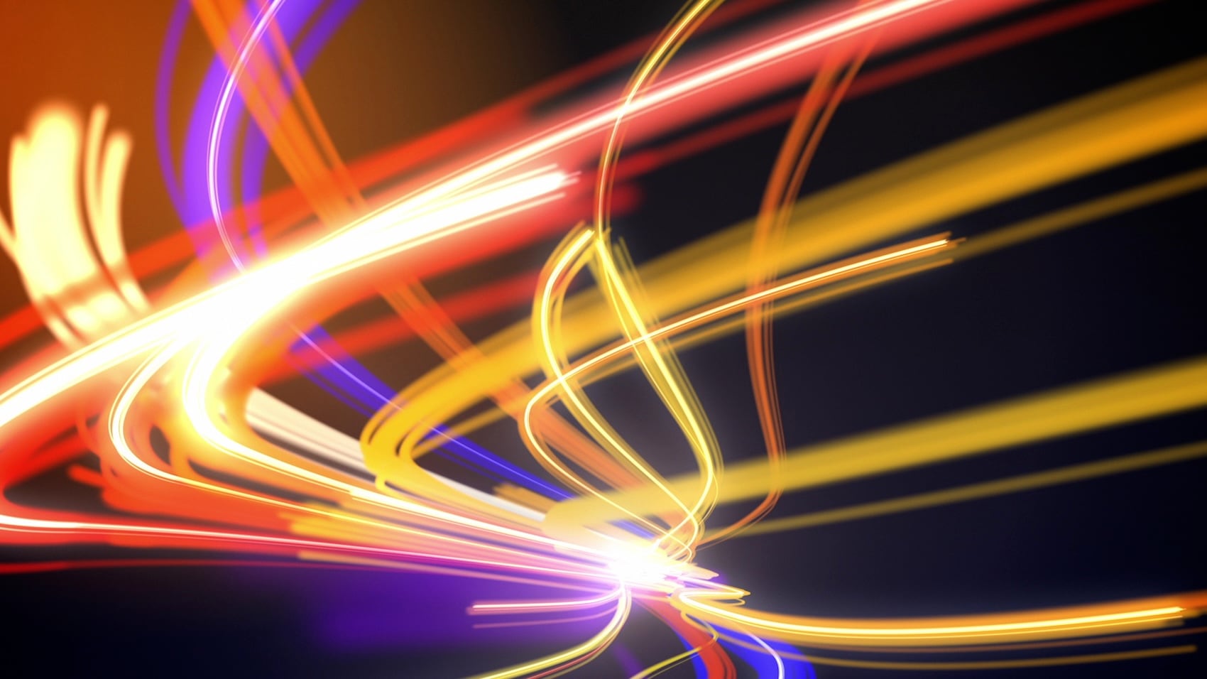 Abstract image of dynamic orange, yellow, and red light trails creating motion and energy on a dark background.