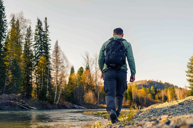 man walking on river bank