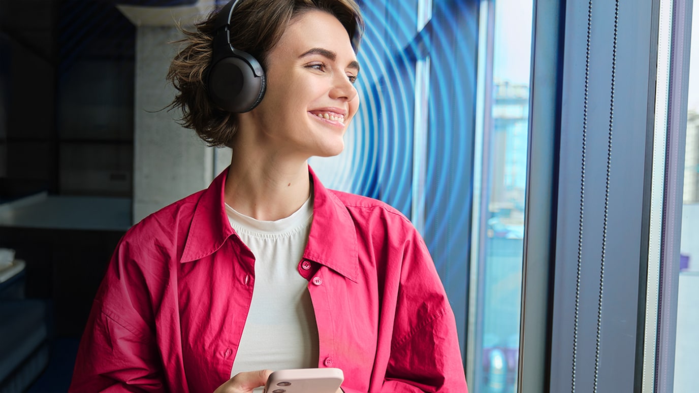 Woman wearing headphones listening to content on her smartphone