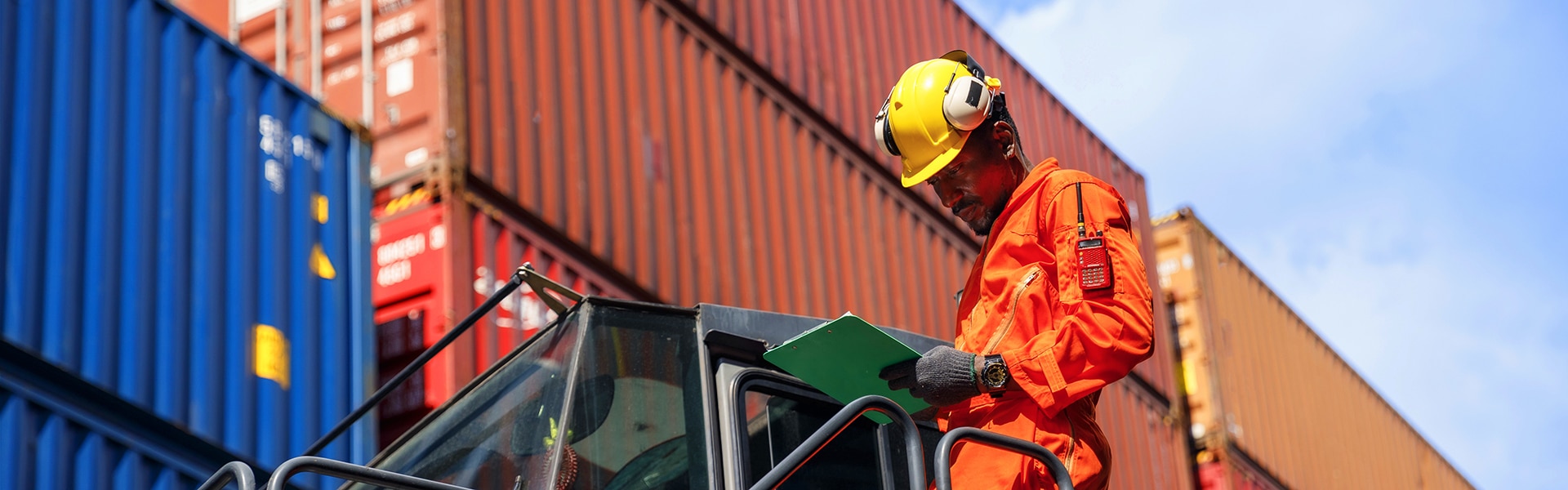 Workman in front of shipping containers