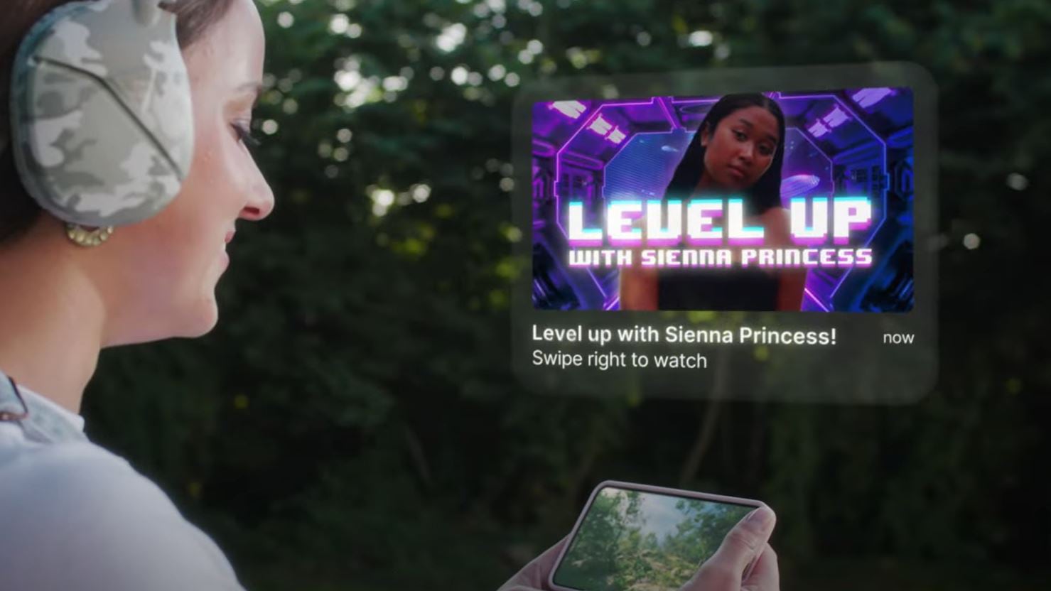 Gamer in camouflaged headphones viewing smartphone with AR image in view