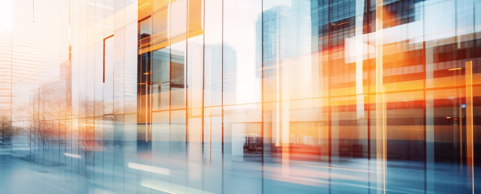Abstract cityscape of modern glass office buildings with motion blur and warm orange light reflections
