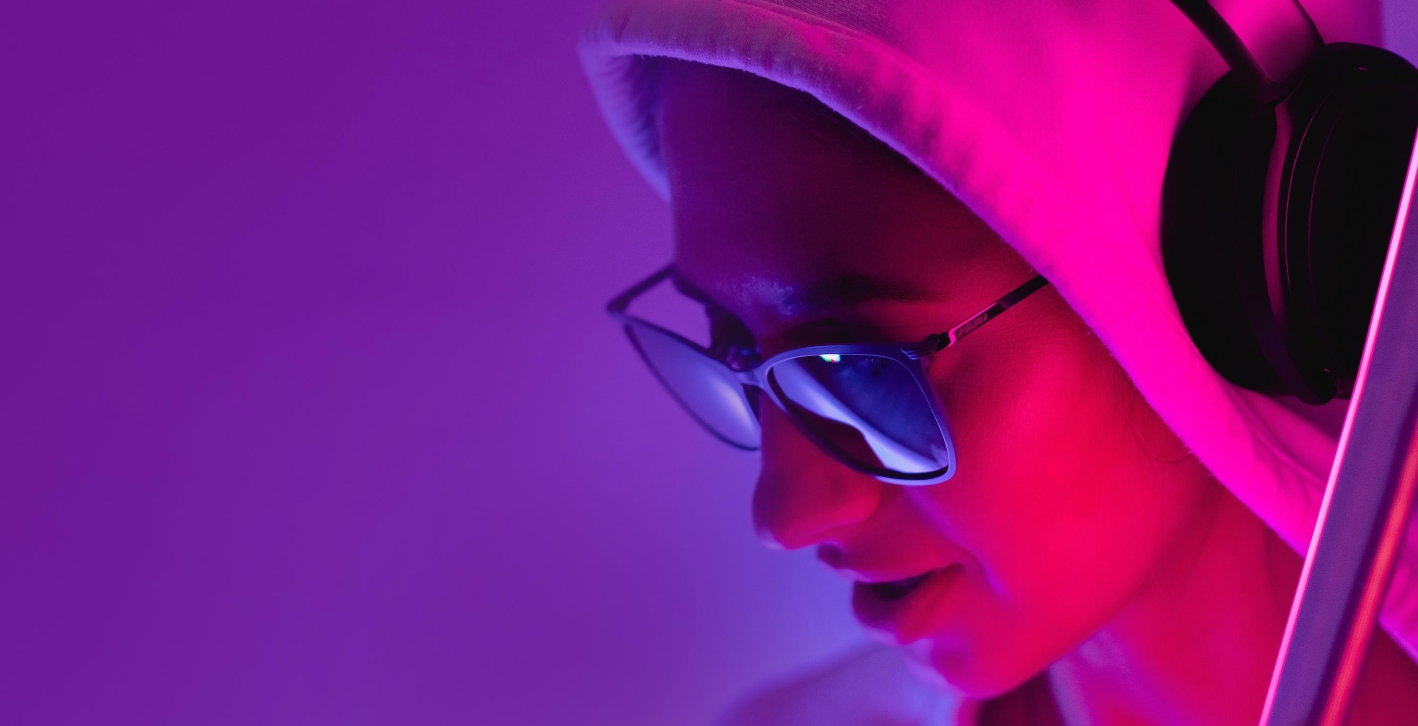 Girl wearing sunglasses and hoodie and listening to music with wireless headphones 