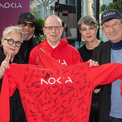 Employees holding a Nokia hoodie with signatures