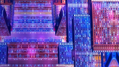 Futuristic data center with symmetrical server racks glowing in blue and pink neon lights, high performance server hubs.