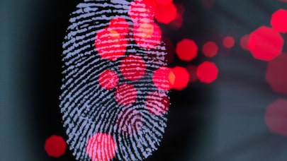Close-up of a fingerprint with red glowing nodes, symbolizing cybersecurity and data tracking