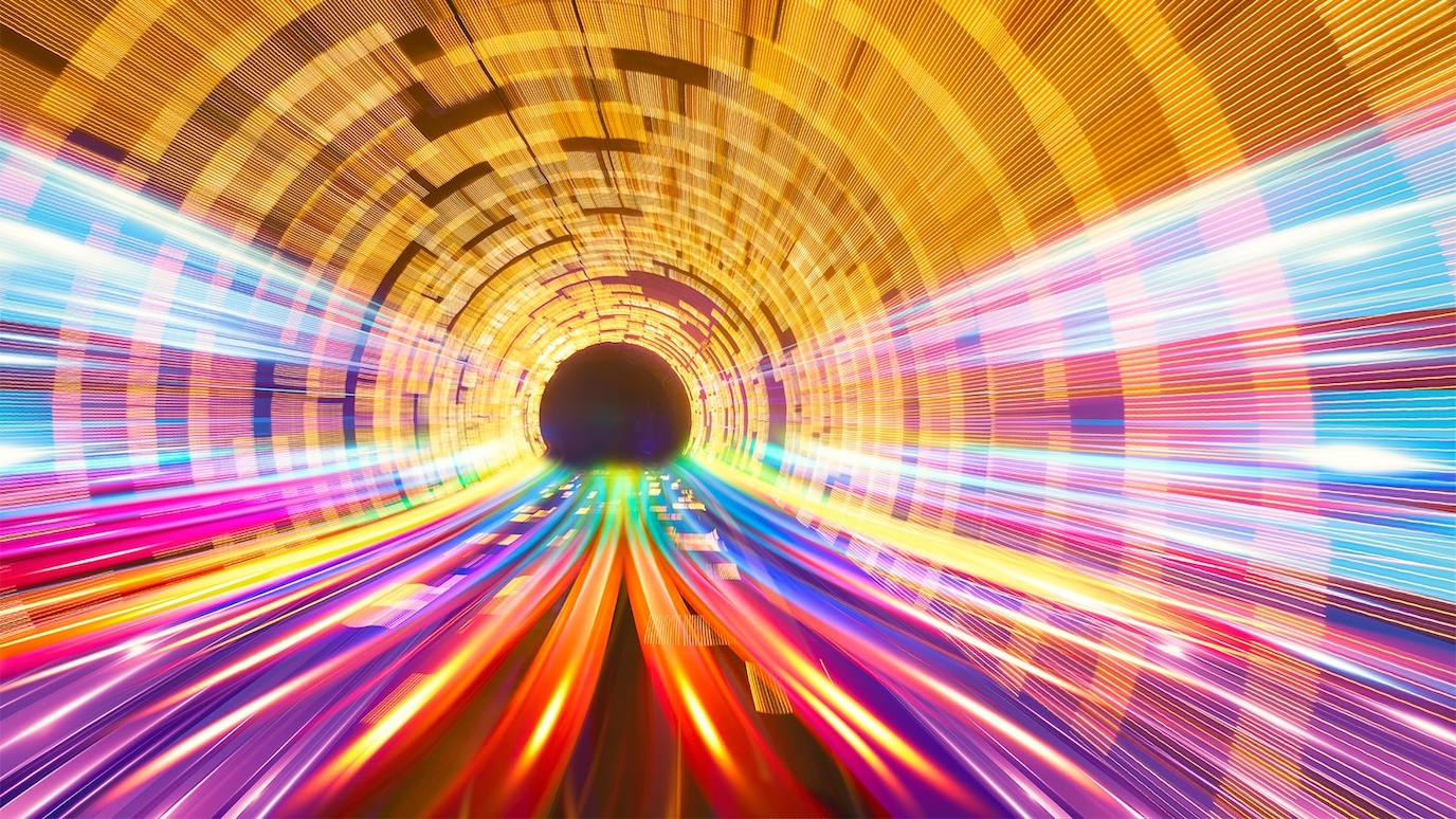 Abstract tunnel of colorful data streams rushing toward a dark center, symbolizing high-speed digital connectivity.