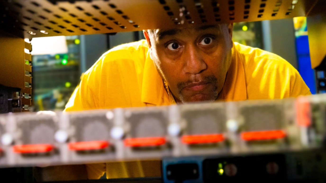 An engineer looking at a data rack