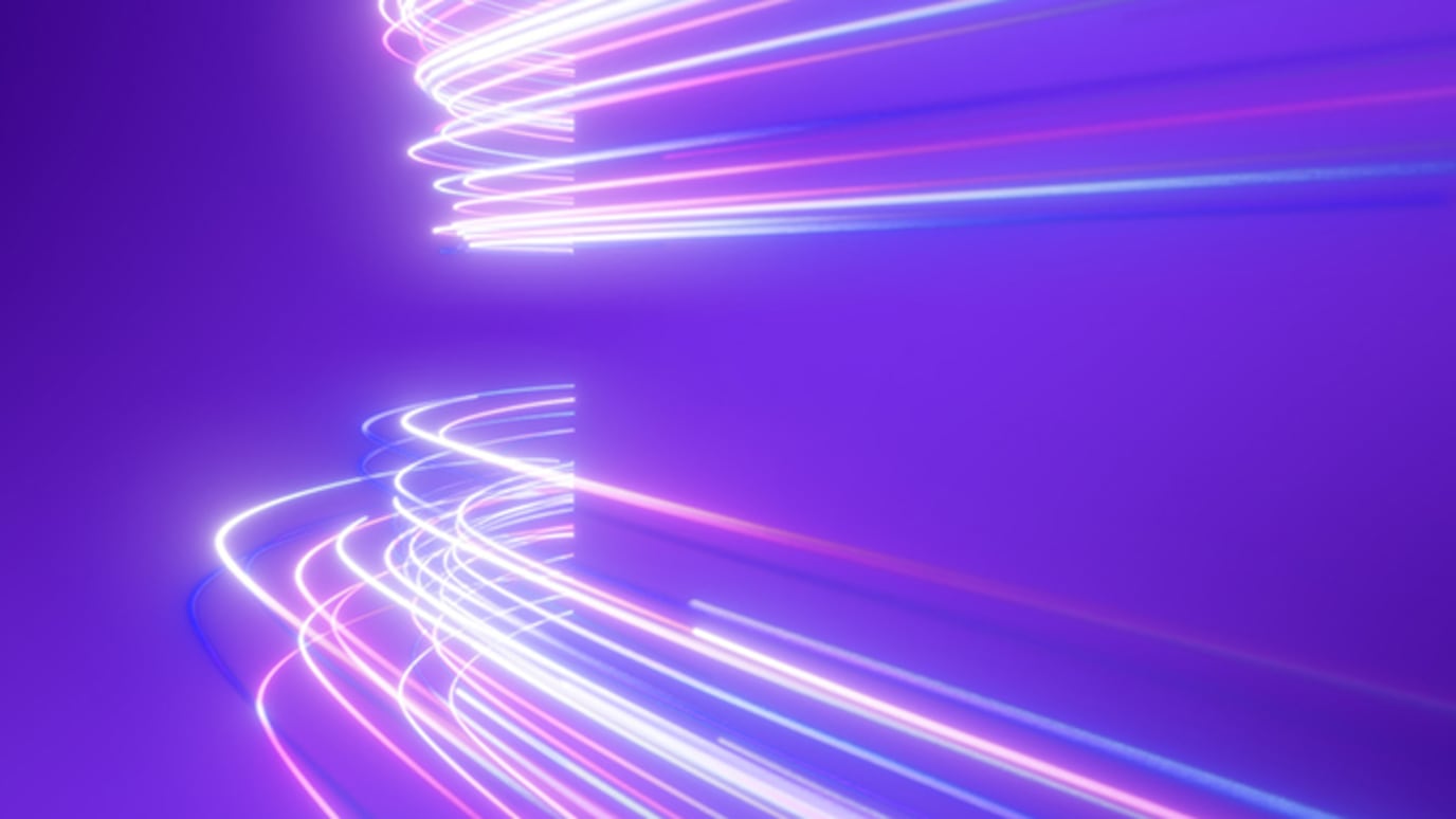 Abstract neon light trails curving on a purple background, futuristic motion effect