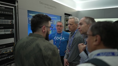 OFC 2026 visitors and exhibitors standing in front of a data center