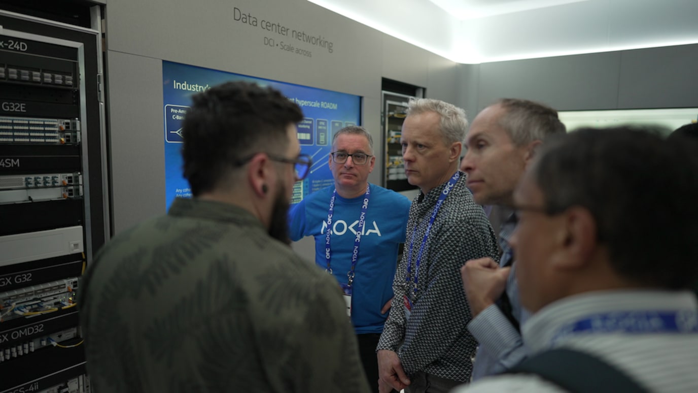 OFC 2026 visitors and exhibitors standing in front of a data center